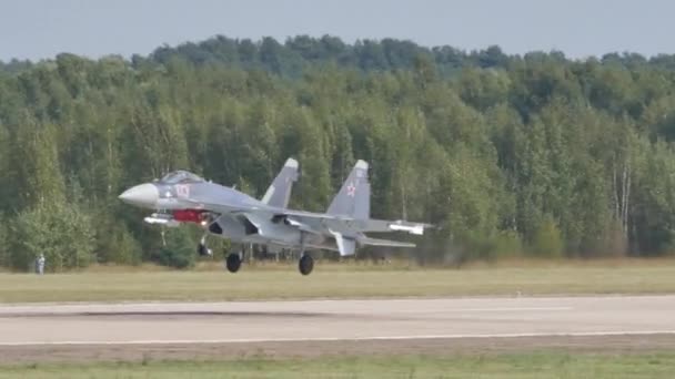 Orosz vadászgép jet repülőgép szürke álcázással landol egy katonai repülőtéren — Stock videók