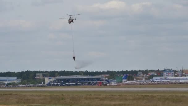 Brandbestrijdende coaxiale rotoren helikopter lossen water uit bambi busket — Stockvideo