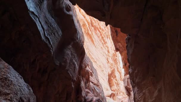 I raggi solari entrano attraverso un'apertura in alto in una grotta in una montagna nel deserto — Video Stock