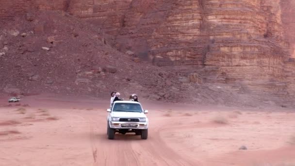 Terénní 4wd s turisty sleduje stopy na červeném písku pouště — Stock video