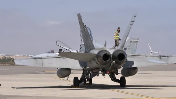 Chasseur d'avion militaire stationné. Le moteur à réaction épuise un mécanicien marchant sur l'aile — Video