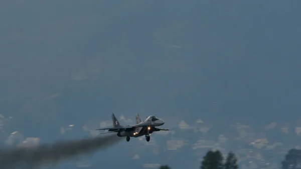 Military plane in flight with black smoke from engines. Air pollution concept — Stock Photo, Image