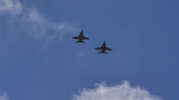 Paar straaljagers tijdens de vlucht in formatie in de blauwe lucht van onderaf gezien — Stockvideo
