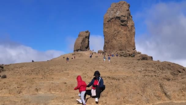 Женщина-туристка с ребенком рядом с большой скальной горой Roque Nublo Гран-Канария, Испания — стоковое видео