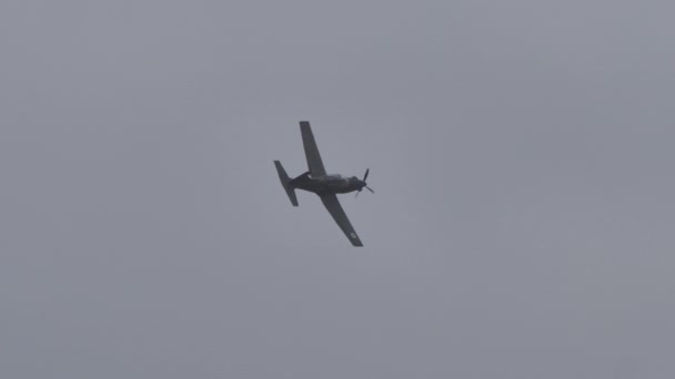 Kleine militaire propeller vallen groen bruin vliegtuig in vlucht in grijze lucht aan — Stockvideo