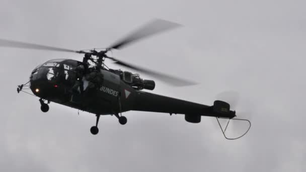 Исторический военный вертолет в полете замедляется и останавливается в зависании — стоковое видео