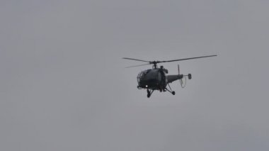 Bulutlu havada klasik askeri helikopter uçuyor. 4K havacılık videosu