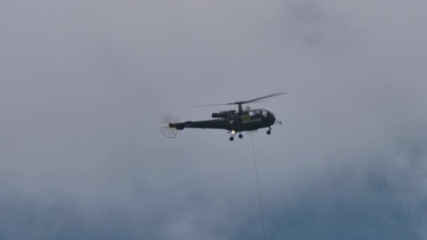 Vintage hélicoptère militaire vol à basse vitesse et altitude dans les montagnes nuageuses — Video