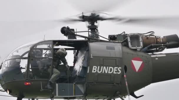 Rescue military helicopter lowers a rescuer with winch while flying stationary — Stockvideo