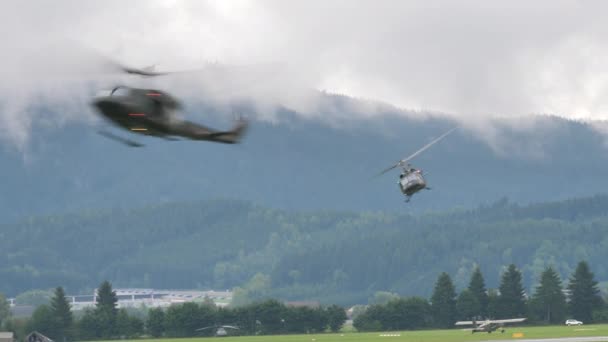 Vojenské helikoptéry zastavují v letu a odpalují lana, ze kterých vojáci shazují — Stock video