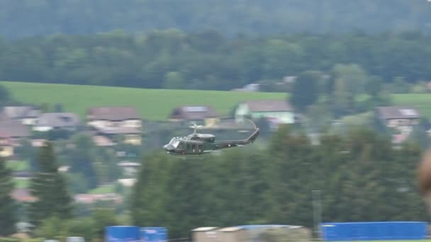 Vojenský vrtulník za letu v nízké výšce v zeleném alpském údolí — Stock video