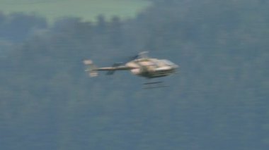 Yeşil vadide küçük hafif askeri helikopter alçak irtifa yüksek hız uçuşu