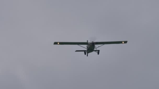 Mały samolot transportowy śmigła uwalnia wodę tworząc zielony szlak — Wideo stockowe
