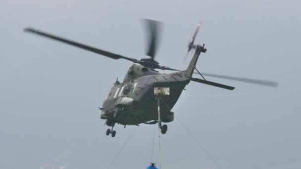 Военный вертолет НАТО в полете на низкой скорости на малой высоте повернул направо — стоковое видео