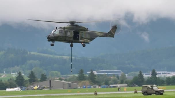 Military helicopter in flight at low altitude in a green mountain valley — 비디오