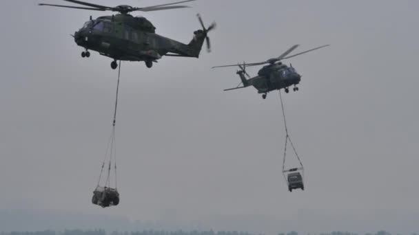 Military helicopters in flight with loads hanging underneath. NATO army training — ストック動画