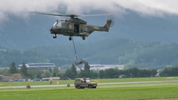 Helicóptero militar repousa no chão um veículo off-road que transportava — Vídeo de Stock