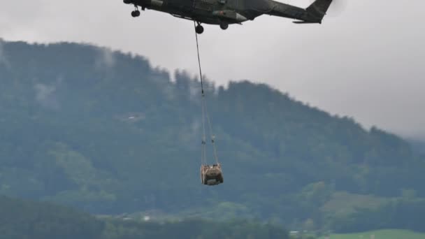 Close-up of military supplies for troops flown by helicopter hanging from a rope — ストック動画