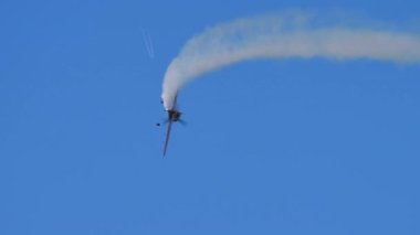 Sukhoi Su-31 açık mavi gökyüzünde baş aşağı uçuyor.