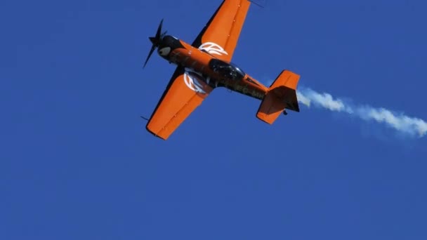 Rotes Akrobatikflugzeug führt Stunts bei klarem blauen Himmel aus — Stockvideo