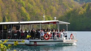 Turistler Kozjak Gölü 'nde feribot yolculuğunun keyfini çıkarıyorlar. Plitvice Lakes Ulusal Parkı Hırvatistan