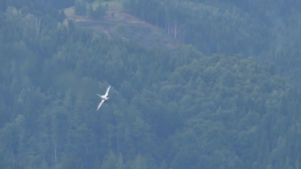 Military fighter jet airplane in flight at high speed close to green mountain — Vídeos de Stock