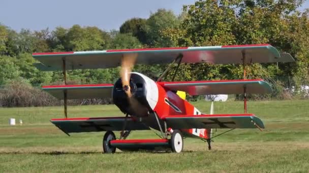 Červený historický trojplošník bojové letadlo pohon na letišti — Stock video