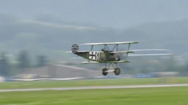 Zeltweg, Avusturya SEPTEMBER, 6, 2019 1. Dünya Savaşı havacılığı uçağı Kızıl Baron 'u, çimen havaalanı üzerinde yüksek hızda alçaktan uçarken yakaladı. Fokker Dr.1 Triplane 1. Dünya Savaşı pervaneli savaş uçağı.