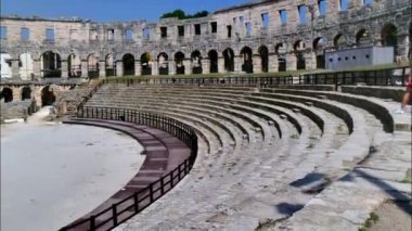 Pula Croatia AUGUST, 15, 2020 Interiors of Pula Arena Roman amphitheater with tourists on stone bleachers. 4K timelapse in sunny summer day. Motion blur effect, unrecognizable people