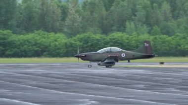 Cerklje ob Krki Slovenia MAY 29, 2022 Modern light bomber propeller aircraft taxiing with green forest background. Pilatus PC-9M of Slovenian Air Force with rockets and small bombs under the wings