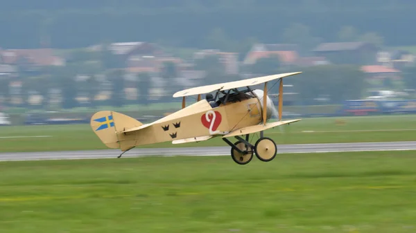 Zeltweg, Austria SEPTEMBER, 6, 2019 Vintage biplane of First World War WWI in grey heavy rain cloudy sky. FVM CVM O1 Tummelisa propeller plane of Swedish Air Force. Copy space.