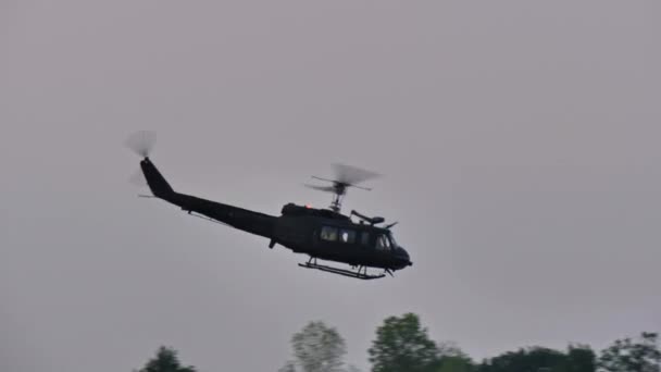 ピアチェンツァイタリアJune 2022木の上に低レベルで飛行中のレトロな軍用ヘリコプター Agusta Bell Ab205 1捜索救助任務中の濃い緑色の模倣カモフラージュの軍隊の英雄 — ストック動画