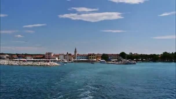 フェリー船からクロアチア国立公園へ Brijuni ブリユニ 島のファザナの漁村を背景に クロアチア国旗を前景に — ストック動画