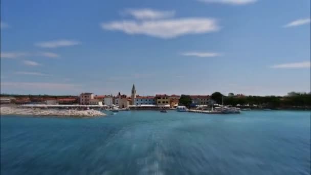フェリー船からクロアチア国立公園へ Brijuni ブリユニ 島のファザナの漁村を背景に クロアチア国旗を前景に — ストック動画