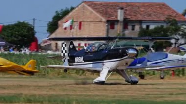 Padua, İtalya 26 Haziran 2022 Küçük akrobatik çift kanatlı uçak kırsal alandaki bir çim pistinden kalkıyor. Pitts S2b eski bir çiftlikteki yerel hava gösterisi sırasında aşırı akrobatik bir uçak.