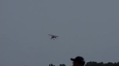 Padua, İtalya, 26 Haziran 2022 Biplane arka planda mısır tarlası olarak görülen kanat kayması nedeniyle küçük bir kırsal havaalanına iner. Pitts S2 Amerikan tarihi uçağı