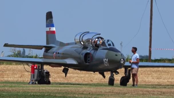 パドヴァ イタリアJune 2022スペシャリストは 小さな古い軍用ジェットのパイロットが芝生の滑走路から離陸する前にエンジンを始動するのを助けます ソコG 2ガレブ ユーゴスラビア空軍 — ストック動画