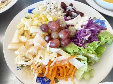 Yeşil salata yapraklı bir tabak, salatalık, feta, kırmızı soğan ve zeytin.