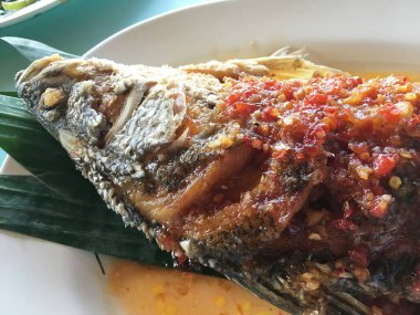 Kızarmış balık taze otlar ve plaka üzerinde tatlı baharatlı sos ile