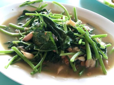 Kızarmış su ıspanak beyaz tabağını karıştır