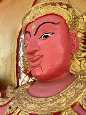 Altın duvarda kırmızı açı heykeli