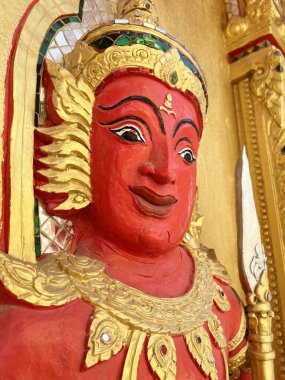 Altın duvarda kırmızı açı heykeli