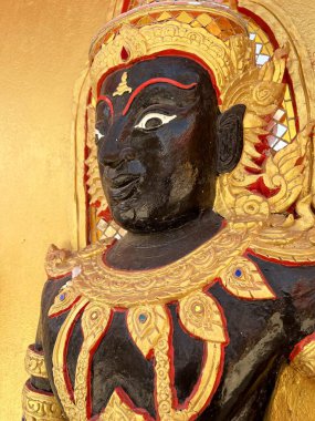 Altın duvarda siyah açılı heykel