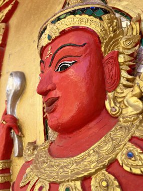 Altın duvarda kırmızı açı heykeli