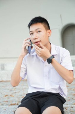 Yakışıklı adam bahçede akıllı telefon kullanıyor.