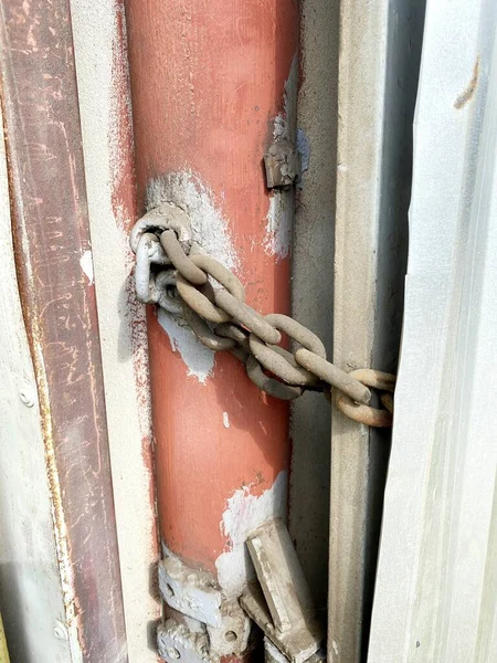 Lock on a chain on a rusty metal container