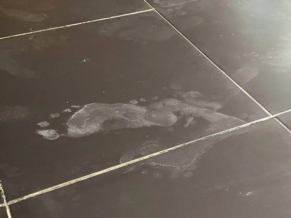 Foot footprint in a dust on a floor