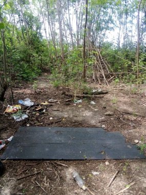 Yeşil yapraklı tahta bir bankın dikey görüntüsü.