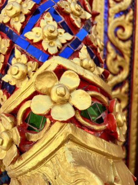 gold flower statue on temple wall at Thailand