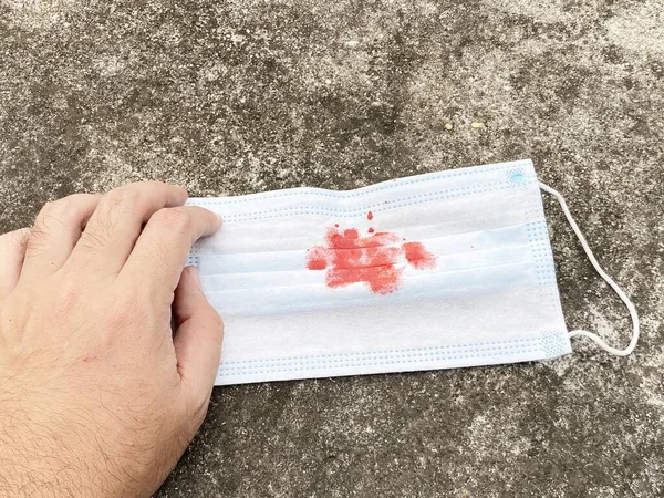 hand holding a medical mask with a white background